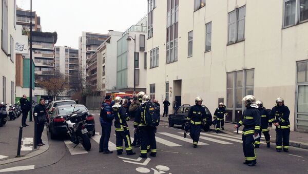 Police officers and firefighters gather in front of the offices of the French satirical newspaper Charlie Hebdo in Paris on January 7, 2015 - Sputnik International