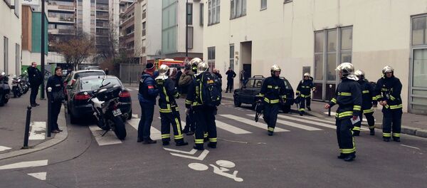 Police officers and firefighters gather in front of the offices of the French satirical newspaper Charlie Hebdo in Paris on January 7, 2015 - Sputnik International