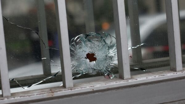 A bullet impact is seen in a window of a building next to the French satirical newspaper Charlie Hebdo's office in Paris. Wednesday, January 7, 2015. - Sputnik International