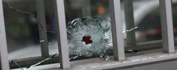 A bullet impact is seen in a window of a building next to the French satirical newspaper Charlie Hebdo's office in Paris. Wednesday, January 7, 2015. - Sputnik International