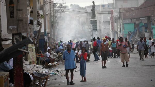 Displaced Haitians whose homes were damage during the earthquake gather in a street of Port-au-Prince, Friday, Jan. 15, 2010. - Sputnik International
