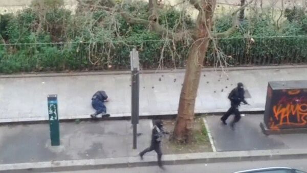 Gunmen flee after shooting a wounded police officer (L) on the ground at point-blank range, outside the offices of French satirical newspaper Charlie Hebdo in Paris - Sputnik International