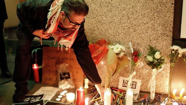 A man places a candle at a makeshift memorial outside the Consulate General of France during a vigil to pay tribute to the victims of an attack on satirical magazine Charlie Hebdo in Paris, in San Francisco, California January 7, 2015 - Sputnik International