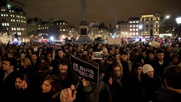People hold up pens and posters reading 'I am Charlie' in French as they take part in a vigil of people, including many who were French, to show solidarity with those killed in an attack at the Paris offices of weekly newspaper Charlie Hebdo, in Trafalgar Square, London, Wednesday, Jan. 7, 2015 - Sputnik International