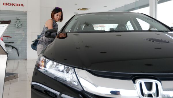 In this Dec. 22, 2014 photo, a woman checks out a new Honda City at a Honda showroom in Petaling Jaya, Malaysia - Sputnik International