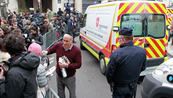 A local resident distributes coffee to reporters gathered at the scene after gunmen stormed a French newspaper, in Paris, Wednesday, Jan. 7, 2015 - Sputnik International
