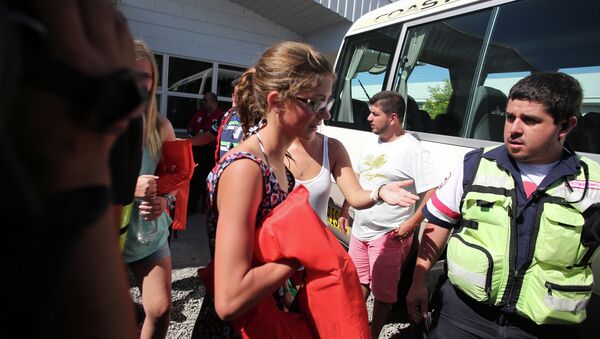 Tourists who were rescued after a catamaran sank off the Pacific coast of Costa Rica are escorted from a Coast Guard station into a bus, in the port of Caldera, Costa Rica, Thursday, Jan. 8, 2015 - Sputnik International