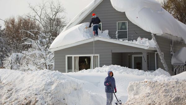 A man clears snow from his roof in the town of Cheektowaga near Buffalo, New York, November 19, 2014 - Sputnik International