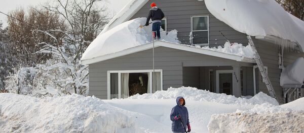 A man clears snow from his roof in the town of Cheektowaga near Buffalo, New York, November 19, 2014 A man clears snow from his roof in the town of Cheektowaga near Buffalo, New York, November 19, 2014 - Sputnik International