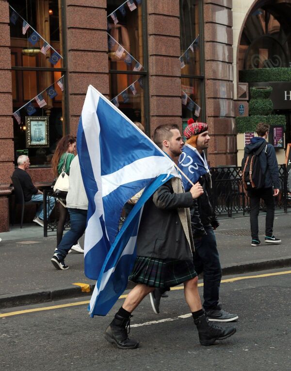 Yes campaigners carry flags on the day Scottish residents decide the future political direction their country will take in Glasgow,Scotland on September 18, 2014 - Sputnik International