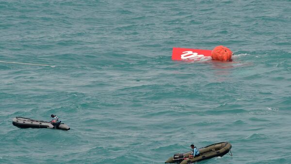 Part of the tail of AirAsia QZ8501 floats on the surface after being lifted as Indonesian navy divers conduct search operations for the black box flight recorders and passengers and crew of the aircraft, in the Java Sea January 10, 2015. - Sputnik International