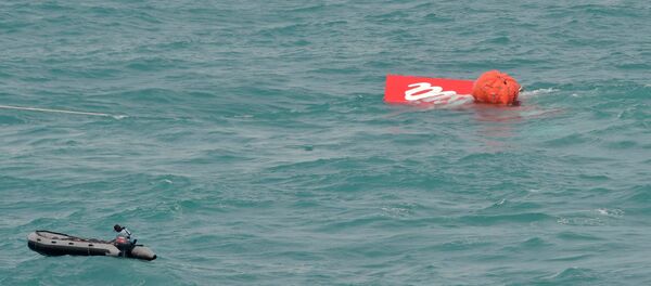 Part of the tail of AirAsia QZ8501 floats on the surface after being lifted as Indonesian navy divers conduct search operations for the black box flight recorders and passengers and crew of the aircraft, in the Java Sea January 10, 2015. - Sputnik International