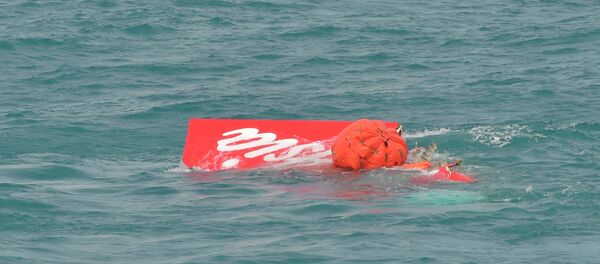 Part of the tail of AirAsia QZ8501 floats on the surface after being lifted as Indonesian navy divers conduct search operations for the black box flight recorders and passengers and crew of the aircraft, in the Java Sea January 10, 2015. - Sputnik International