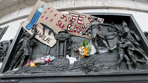 A placard with a news cartoon by French cartoonist Plantu is seen placed amongst other tributes on the statues at the Place de la Republique in Paris - Sputnik International