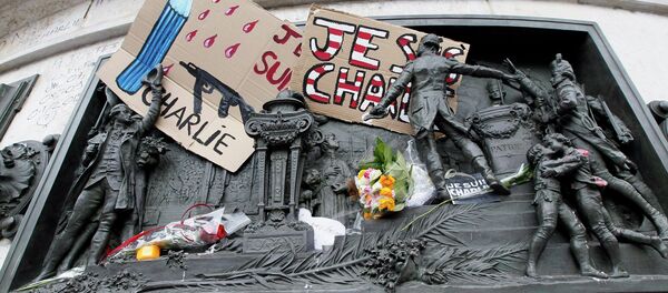 A placard with a news cartoon by French cartoonist Plantu is seen placed amongst other tributes on the statues at the Place de la Republique in Paris A placard with a news cartoon by French cartoonist Plantu is seen placed amongst other tributes on the statues at the Place de la Republique in Paris - Sputnik International