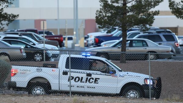 A Fort Bliss Military Police vehicle drives along the perimeter of the El Paso VA parking lot as officers searched for a gunman following a shooting inside the facility Tuesday, Jan. 6, 2014. - Sputnik International