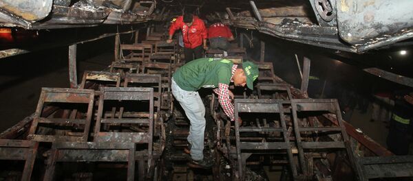 Pakistani rescue workers search through the wreckage of a passenger bus destroyed after colliding with an oil tanker on a highway near Karachi, Pakistan, early Sunday, Jan. 11, 2015. - Sputnik International