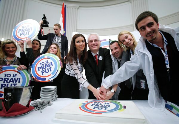 Croatian president and presidential candidate Ivo Josipovic (C) cuts a cake with his supporters after the unofficial results in the headquarters in Zagreb - Sputnik International