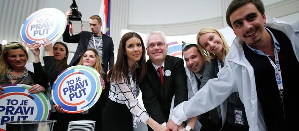 Croatian president and presidential candidate Ivo Josipovic (C) cuts a cake with his supporters after the unofficial results in the headquarters in Zagreb - Sputnik International
