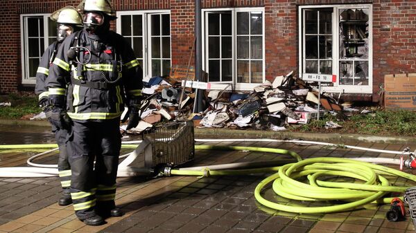 Firefighters stand outside the building of the 'Hamburger Morgenpost' in Hamburg, northern Germany, Sunday morning, Jan. 11, 2015. - Sputnik International