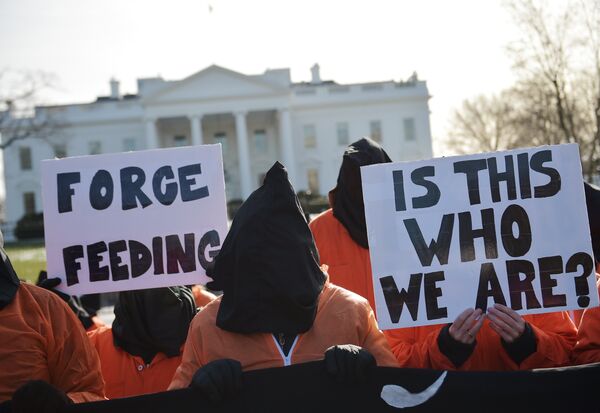 Hooded protestors, some holding placards, take part in a demonstration against the Guantanamo Bay detention facility utside of the White House in Washington Hooded protestors, some holding placards, take part in a demonstration against the Guantanamo Bay detention facility utside of the White House in Washington - Sputnik International