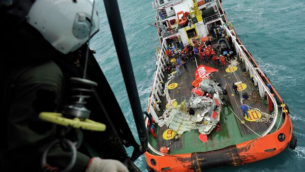The tail of AirAsia QZ8501 passenger plane is seen on the deck of the rescue ship Crest Onyx from an Indonesian Super Puma military helicopter after it was lifted from the sea bed, south of Pangkalan Bun, Central Kalimantan - Sputnik International
