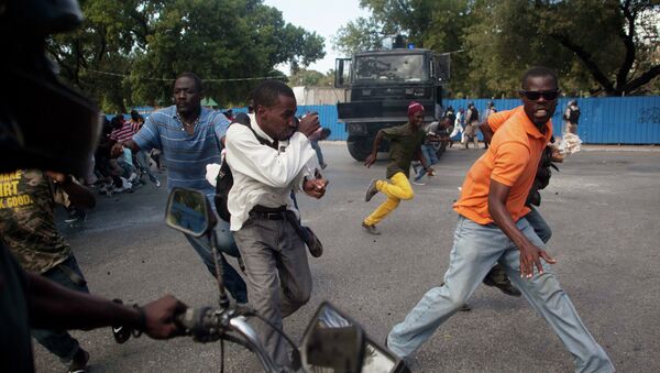 Demonstrators run during a protest demanding the resignation of President Michel Martelly in Port-au-Prince - Sputnik International