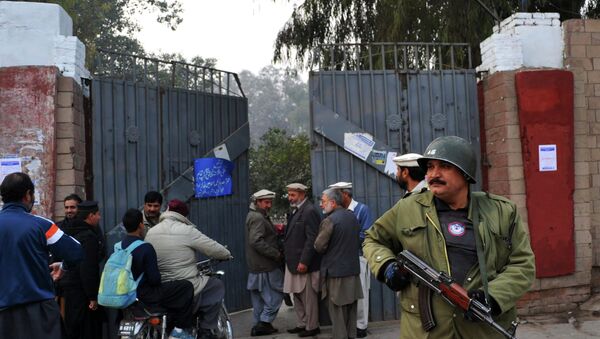 A Pakistani policeman stands guard outside a government school after schools in the city reopened following a Taliban attack in Peshawar on January 12, 2015. - Sputnik International