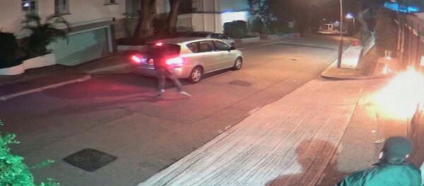 A screen grab of CCTV camera footage shows a security guard looking on as a firebomb explodes at the gate after an unidentified person wearing a mask threw it towards Hong Kong media tycoon Jimmy Lai's home in Hong Kong early January 12, 2015. A screen grab of CCTV camera footage shows a security guard looking on as a firebomb explodes at the gate after an unidentified person wearing a mask threw it towards Hong Kong media tycoon Jimmy Lai's home in Hong Kong early January 12, 2015. - Sputnik International