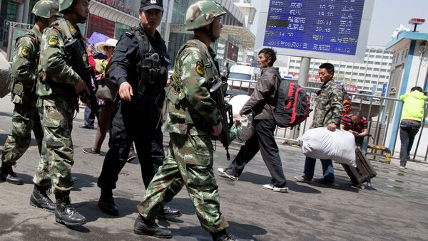 Armed Chinese paramilitary policemen march past the site of the explosion outside the Urumqi South Railway Station in Urumqi in northwest China's Xinjiang Uygur Autonomous Region, 2015. - Sputnik International
