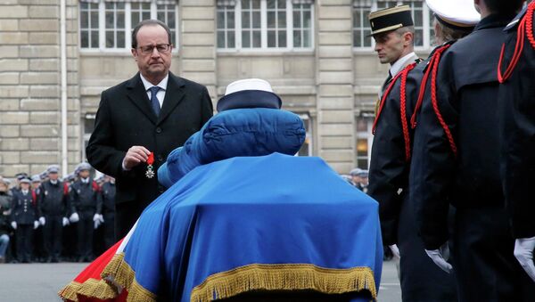 French President Francois Hollande holds a medal in front of the coffin of late police officer Clarissa Jean-Philippe during a national tribute at the Paris Prefecture for the three police officers killed during last week's attacks by Islamic militants, January 13, 2015. - Sputnik International