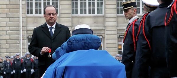 French President Francois Hollande holds a medal in front of the coffin of late police officer Clarissa Jean-Philippe during a national tribute at the Paris Prefecture for the three police officers killed during last week's attacks by Islamic militants, January 13, 2015. - Sputnik International