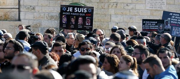 A mourner holds a placard with pictures of the victims of an attack on a Paris grocery on Friday, during their joint funeral in Jerusalem January 13, 2015. A mourner holds a placard with pictures of the victims of an attack on a Paris grocery on Friday, during their joint funeral in Jerusalem January 13, 2015. - Sputnik International