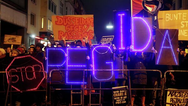 Protesters take part in an anti-racism demonstration against the anti-immigration movement Patriotic Europeans Against the Islamisation of the West (PEGIDA) in Duesseldorf, January 12, 2015 - Sputnik International