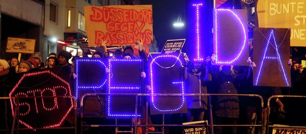 Protesters take part in an anti-racism demonstration against the anti-immigration movement Patriotic Europeans Against the Islamisation of the West (PEGIDA) in Duesseldorf, January 12, 2015 - Sputnik International