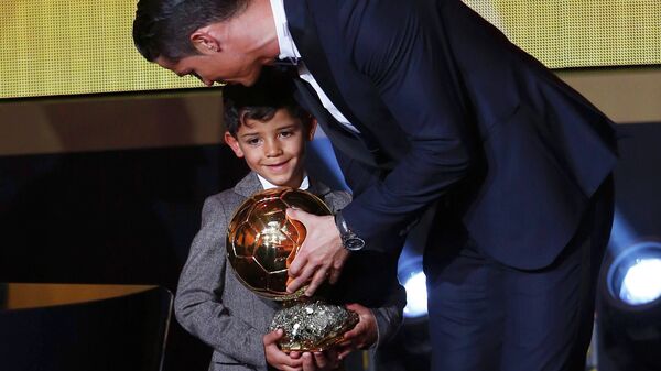 Real Madrid's Cristiano Ronaldo of Portugal, stands with his son Cristiano Ronaldo Jr, after winning the FIFA Ballon d'Or 2014 during the soccer awards ceremony at the Kongresshaus in Zurich January 12, 2015 - Sputnik International