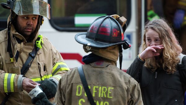 Firefighters speak with a victim after passengers on the Metro (subway) service were injured when smoke filled the L'Enfant Plaza station during the evening rush hour - Sputnik International
