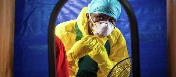 Healthcare worker dons in protective gear before entering an Ebola treatment center in the west of Freetown, Sierra Leone - Sputnik International