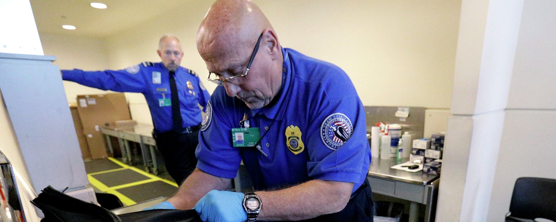 A TSA agent checks a bag at a security checkpoint area at Midway International Airport, Friday, Nov. 21, 2014, in Chicago - Sputnik International, 1920, 11.01.2022