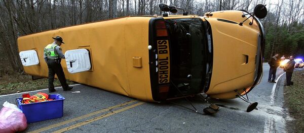 A North Carolina Highway Patrol officer works the scene after a Gaston County school bus overturned in Gastonia, N.C. Wednesday, Jan. 14, 2015 A North Carolina Highway Patrol officer works the scene after a Gaston County school bus overturned in Gastonia, N.C. Wednesday, Jan. 14, 2015 - Sputnik International