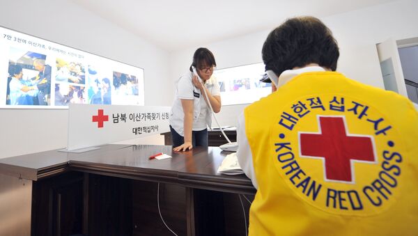 South Korean Red Cross officials talk on the phones as they receive applications for an expected inter-Korean family reunion programme - Sputnik International