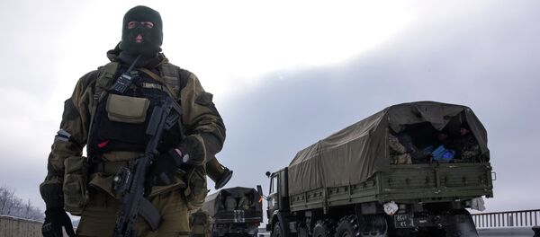 A soldier guards the road near the airport of Donetsk, with Ukrainian military vehicles at rear, Eastern Ukraine, Tuesday, Jan. 6, 2015 A soldier guards the road near the airport of Donetsk, with Ukrainian military vehicles at rear, Eastern Ukraine, Tuesday, Jan. 6, 2015 - Sputnik International