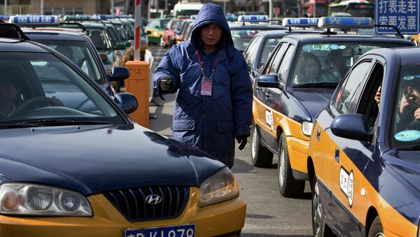A worker stands between the taxis line waiting for customer in Beijing - Sputnik International
