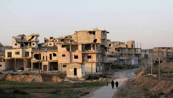 Residents walk near damaged buildings in Maaret al-Naaman town in Idlib province January 14, 2015 - Sputnik International