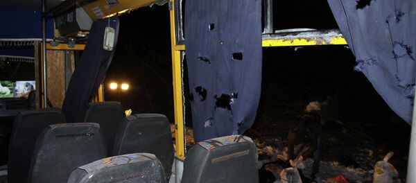 Bodies (R) are laid out next to a damaged bus hit during shelling apparently aimed at a checkpoint manned by Ukrainian forces in Volnovakha, in the eastern Donetsk region - Sputnik International