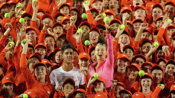 Thanasi Kokkinakis of Australia and Maria Sharapova of Russia pose for a photo with the ball kids of the Australian Open  - Sputnik International
