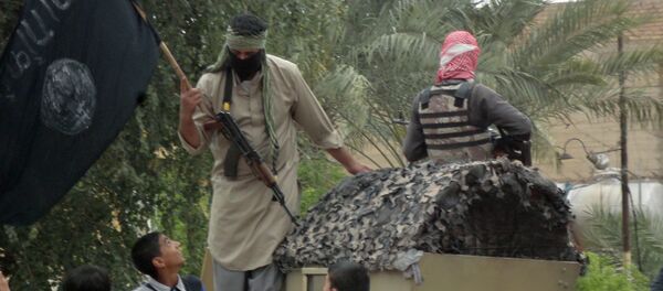Anti-government fighters, one holding a Jihadist flag, are accompanied by Iraqi youth as they ride on a captured Iraqi army vehicle through the streets of the western city of Fallujah on March 29, 2014 - Sputnik International