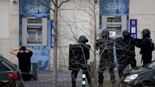 A suspect in a hostage taking situation is detained by members of special French RAID forces outside the post offices in Colombes outside Paris, January 16, 2015 - Sputnik International
