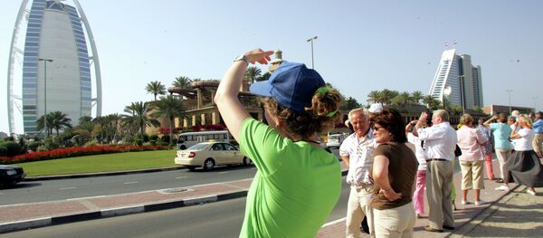 Tourists take pictures of the Burj al-Arab (L) and Jumeirah Beach Hotel in Dubai - Sputnik International