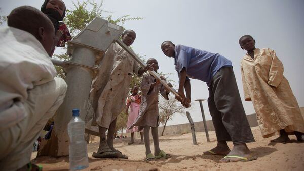 Children pump water to drink from a well in the courtyard of a walk-in feeding center in Dibinindji, a desert village in the Sahel belt of Chad, Wednesday, April 18, 2012 - Sputnik International